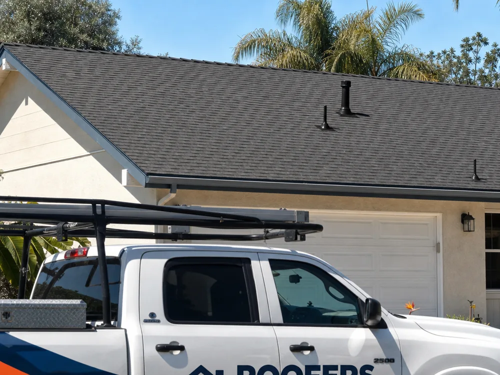 Completed residential shingle roof with a clean ridge line and new pipe-jack flashing